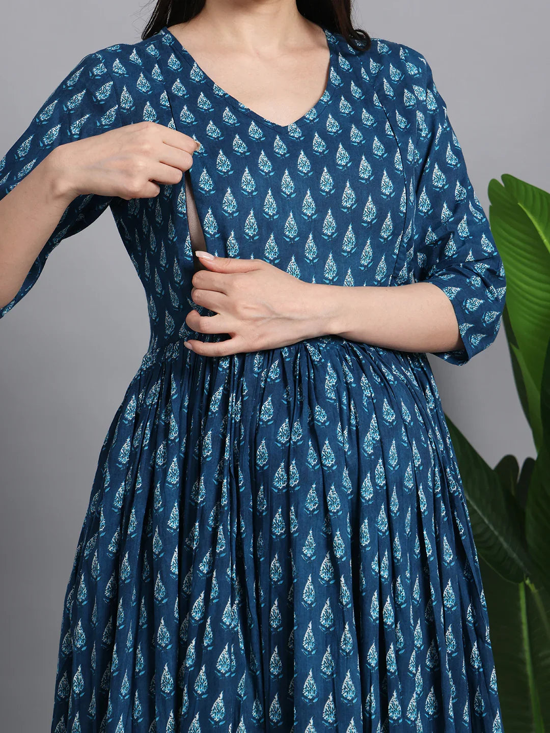 Woman wearing a blue printed maternity and nursing dress with side zipper for breastfeeding access
