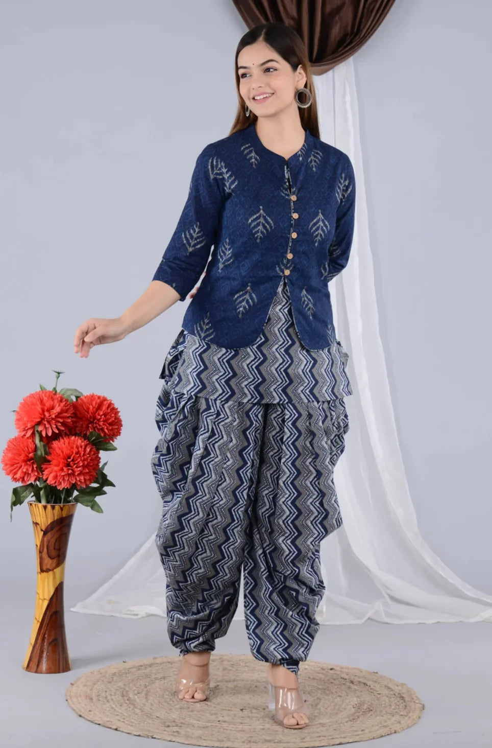 Woman in blue printed maternity kurta and zigzag patterned dhoti pants, standing indoors