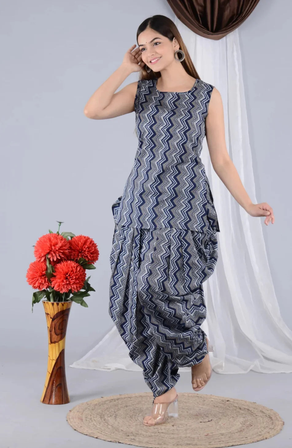 Woman wearing sleeveless blue zigzag maternity kurta and dhoti pants, standing indoors